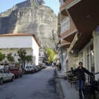 Sally waiting at the bus stop in Kalambaka with the monoliths of Meteora in the background