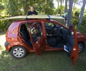 Randy and his surfboard with their rental car