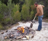 Sam tending to the fire by the Lindsay River