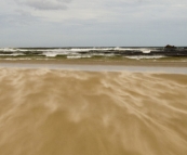 Powerful seas and wisps of flying sand at the mouth of the Pieman River