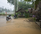 A torrential downpour we escaped in a roadside eatery (which happened to have the best BBQ chicken Lisa tried anywhere in Southeast Asia)