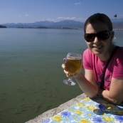 Lisa knocking back an Efes with bread-hungry fish in the water behind her