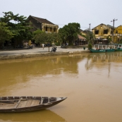 A fisherman with Hoi An\'s old town in the background