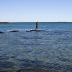 Sam fishing off the rocks at our secluded campsite north of Pago