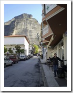 Sally waiting at the bus stop in Kalambaka with the monoliths of Meteora in the background