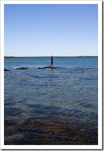 Sam fishing off the rocks at our secluded campsite north of Pago