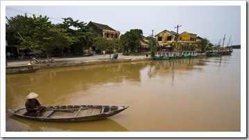 A fisherman with Hoi An's old town in the background