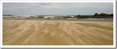 Powerful seas and wisps of flying sand at the mouth of the Pieman River