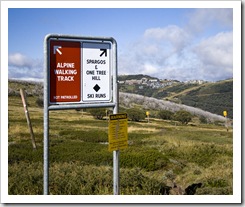 Signs on the way to Derrick Hut with Mount Hotham village in the distance