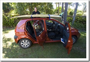 Randy and his surfboard with their rental car