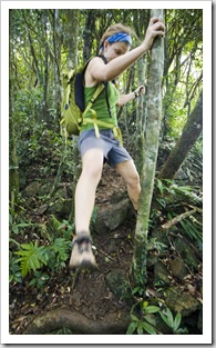 Lisa clambering down wet roots from Mount Sorrow