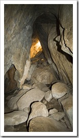 The narrow tunnel out of Bauhinia Cave with sunlight at the opening