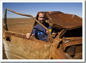 Sam in a burned-out car on the side of the road on the way to Bedourie